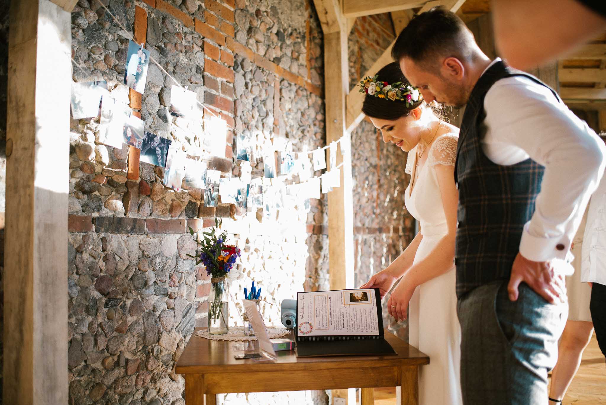Para młoda ogląda księgę gości - wesele w stodole Dyrkowo