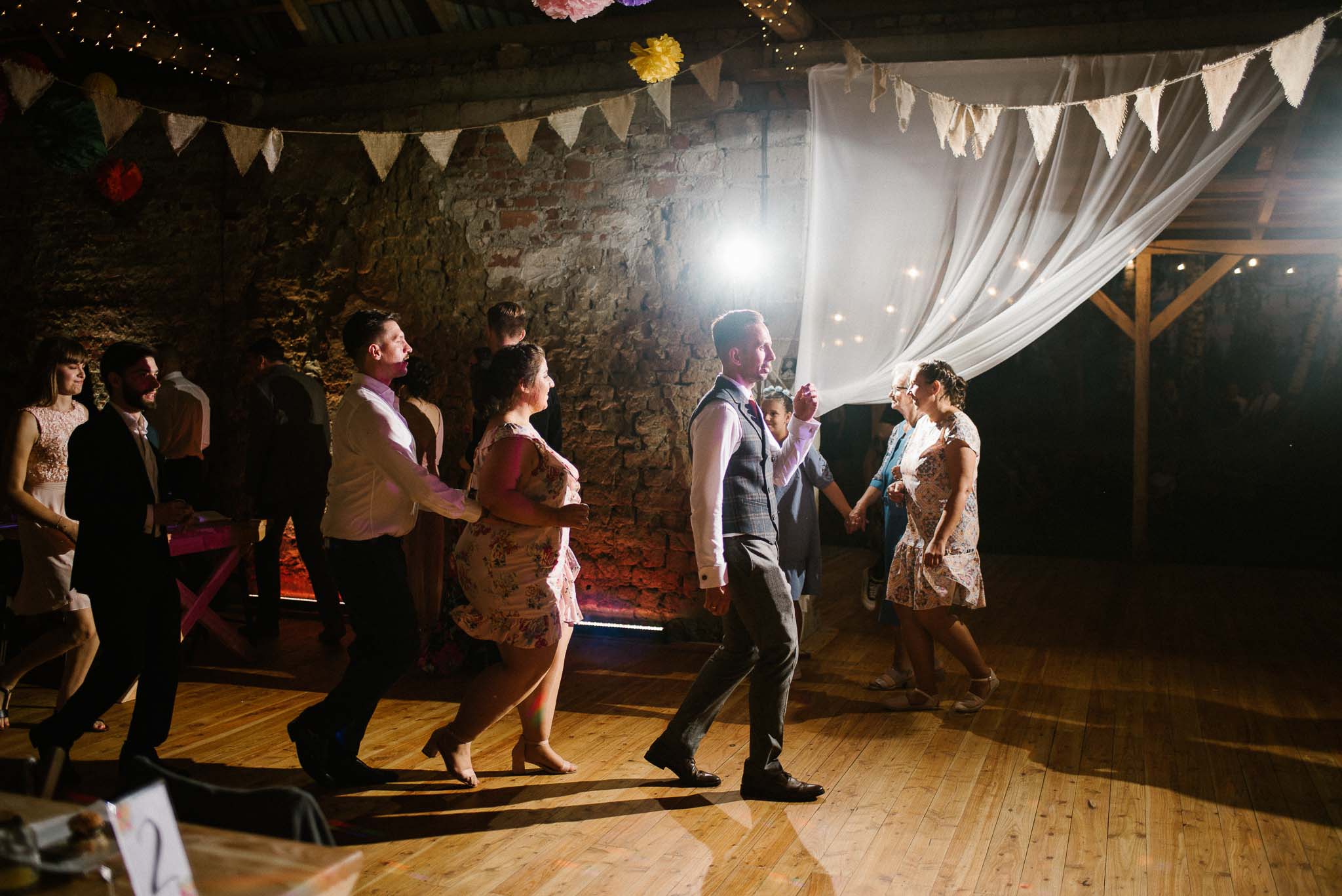 Goście tańczą pociąg na weselu w stodole - ślub w stodole Dyrkowo