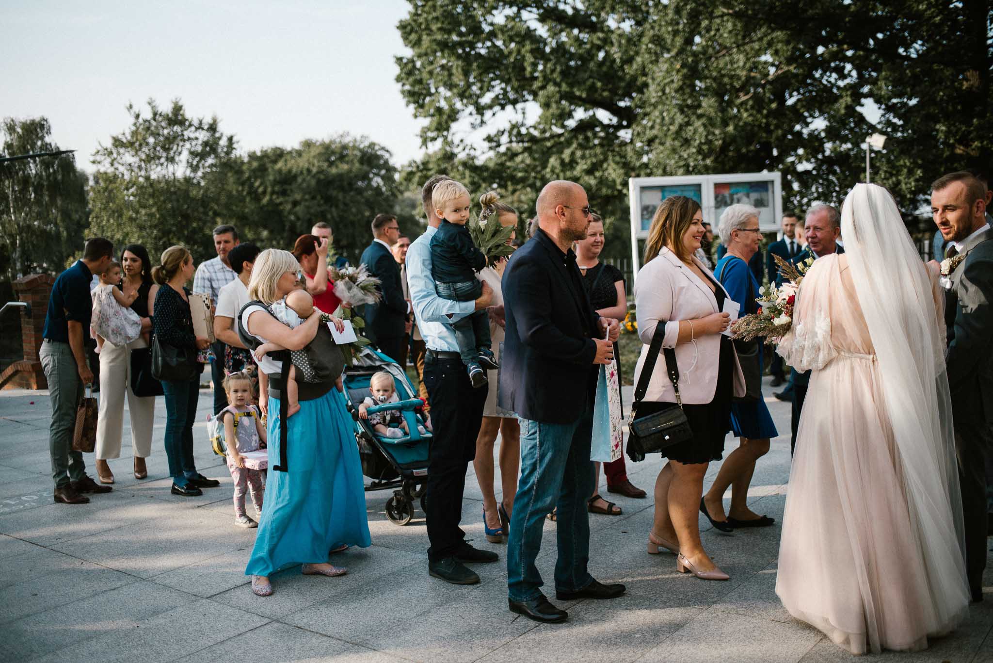 Goście przed kościołem w Poznaniu - ślub w Biskupicach, Siedem Drzew