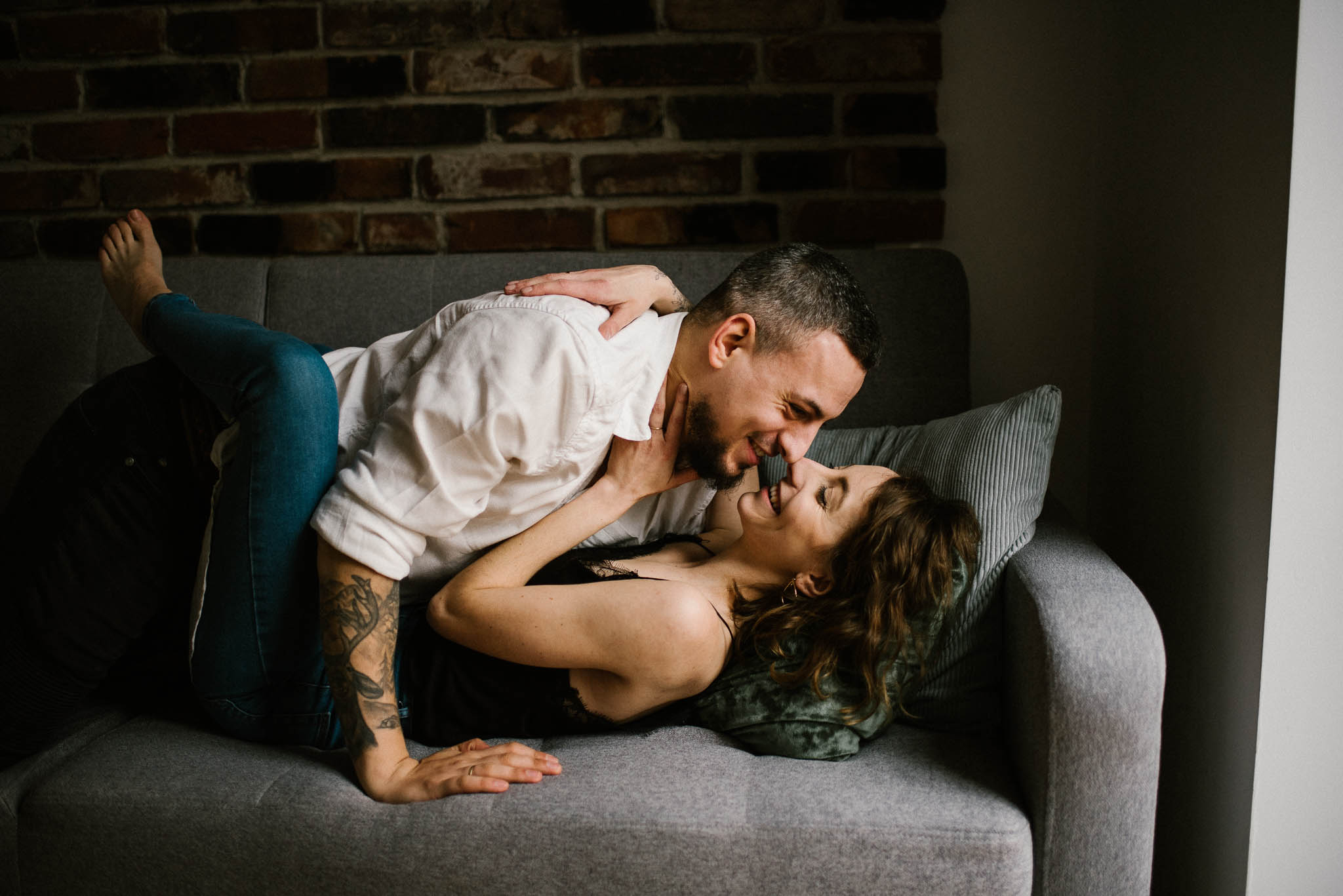 Małżeństwo leży na kanapie i się całuje - sesja sensualna pary lifestyle w Poznaniu