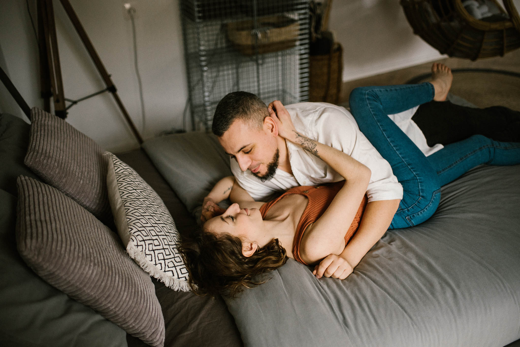 Mąż leży na łóżku i patrzy na swoją żonę - sesja sensualna pary lifestyle w Poznaniu