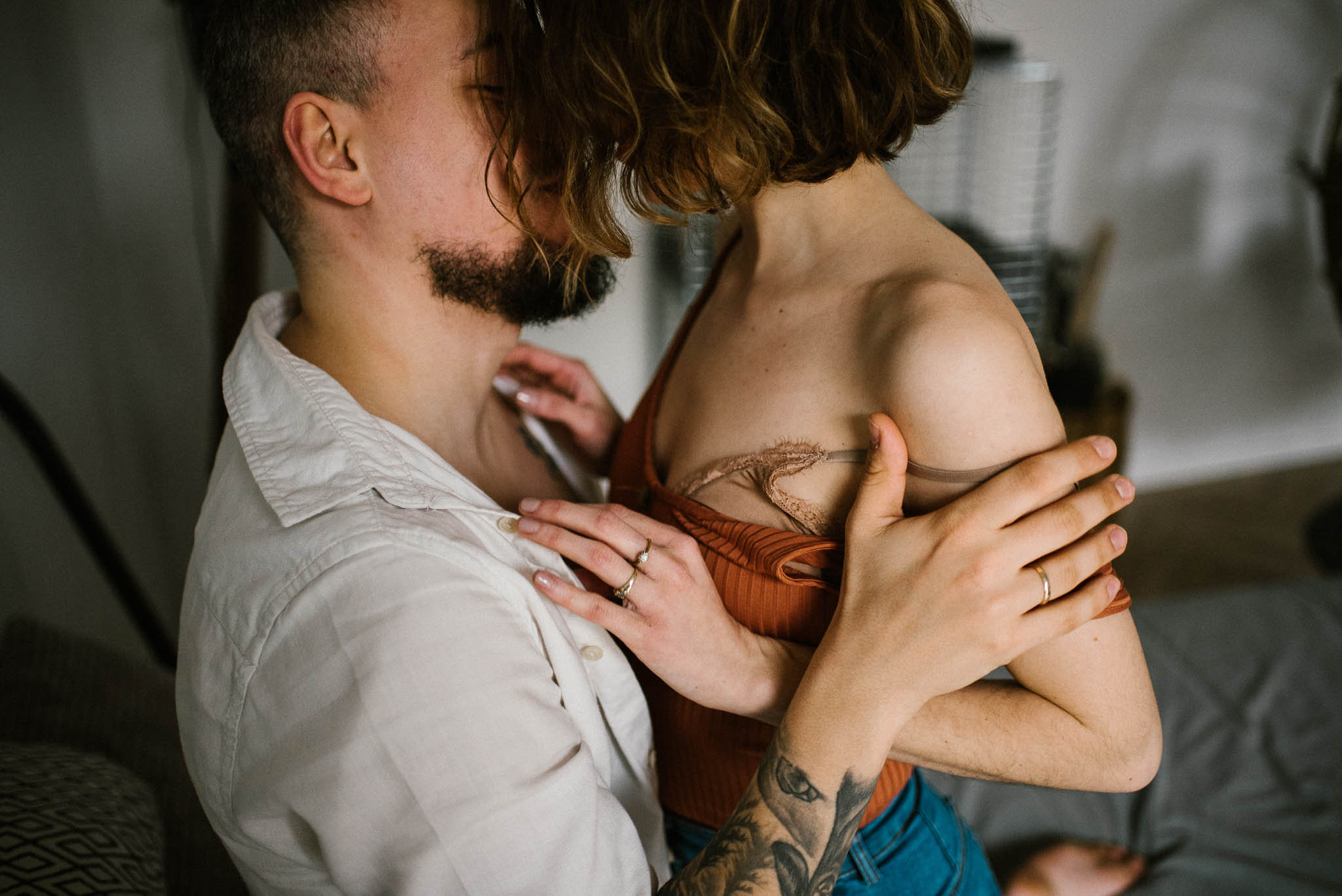 Mąż całuje żonę i trzyma ją za rękę - sesja sensualna pary lifestyle w Poznaniu