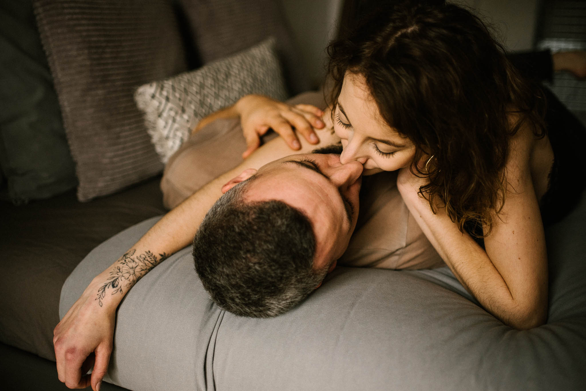 Dziewczyna całuje chłopaka na łóżku w usta - sesja sensualna pary lifestyle w Poznaniu