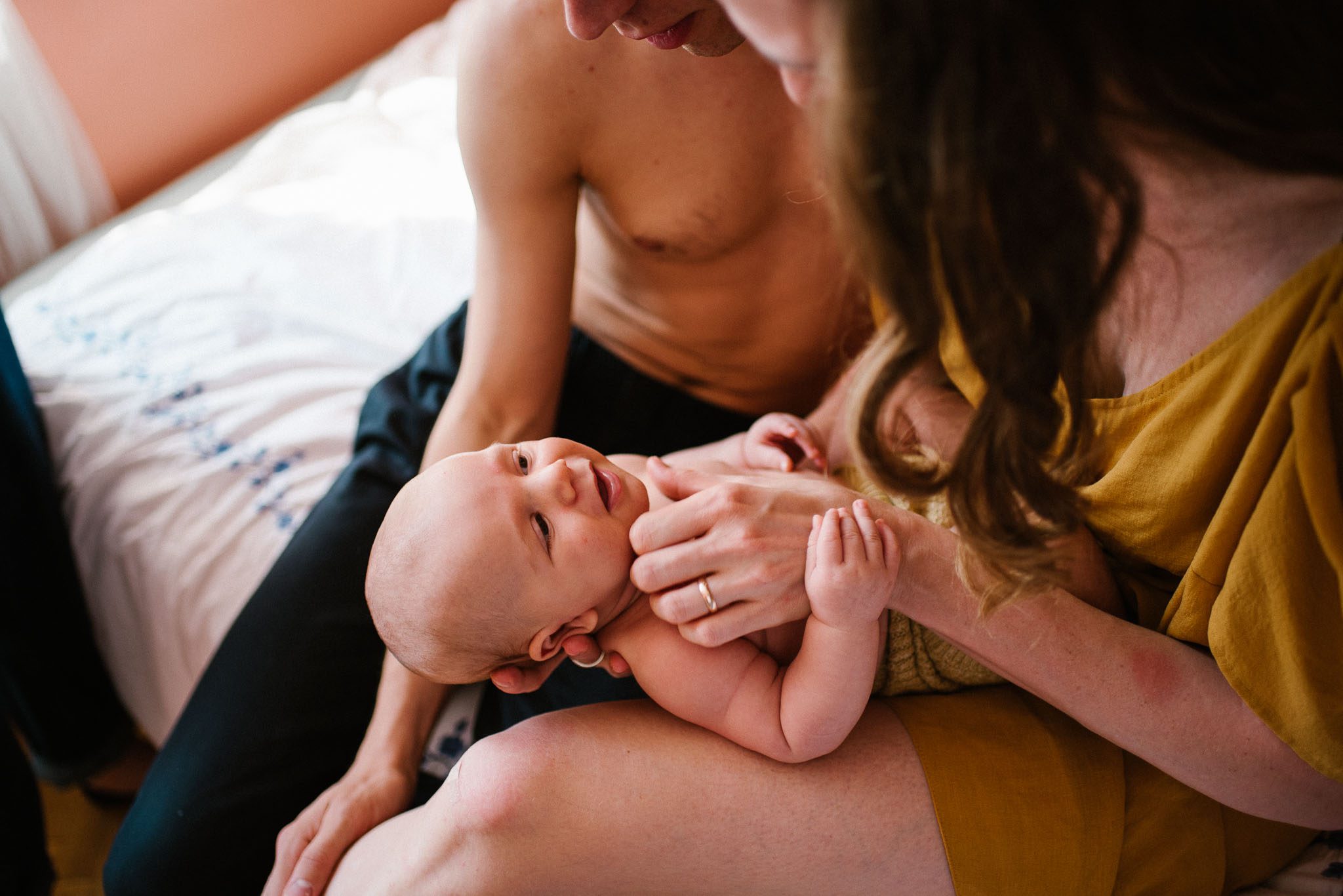 Mama dotyka niemowlę po brodzie - Sesja niemowlęca lifestyle w domu Poznań