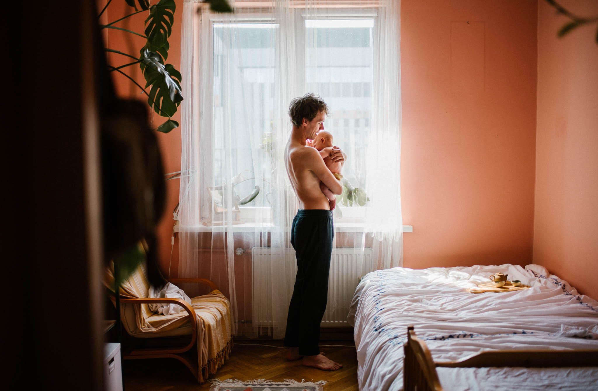 tata nosi synka na rękach -Sesja niemowlęca lifestyle w domu Poznań