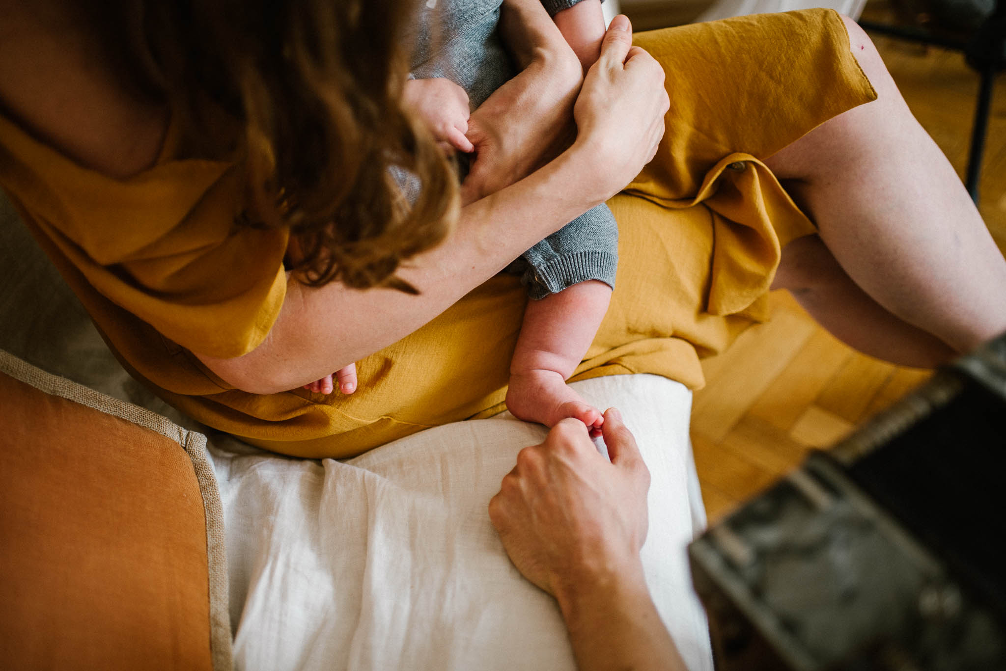 tata dotyka stópek niemowlęcia - Sesja niemowlęca lifestyle w domu Poznań