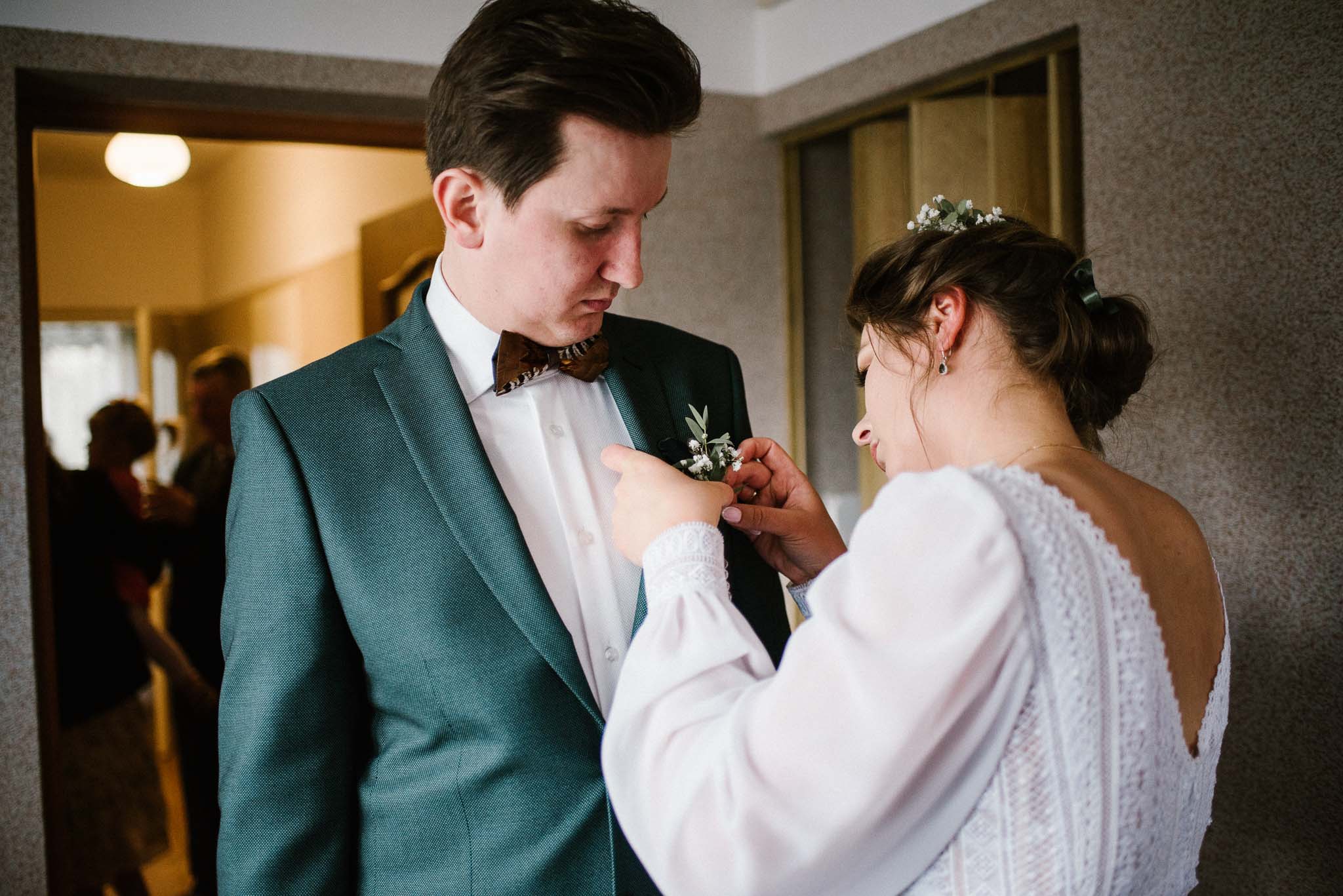 Panna młoda przypina panu młodemu kwiatek do butonierki - sesja ślubna reportaż Żuczki Inowrocław